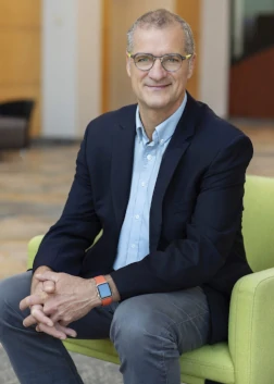 John Dahm, Accra President & CEO, seated in a green chair with hands folded in front of him, looking directly into the cameraee 