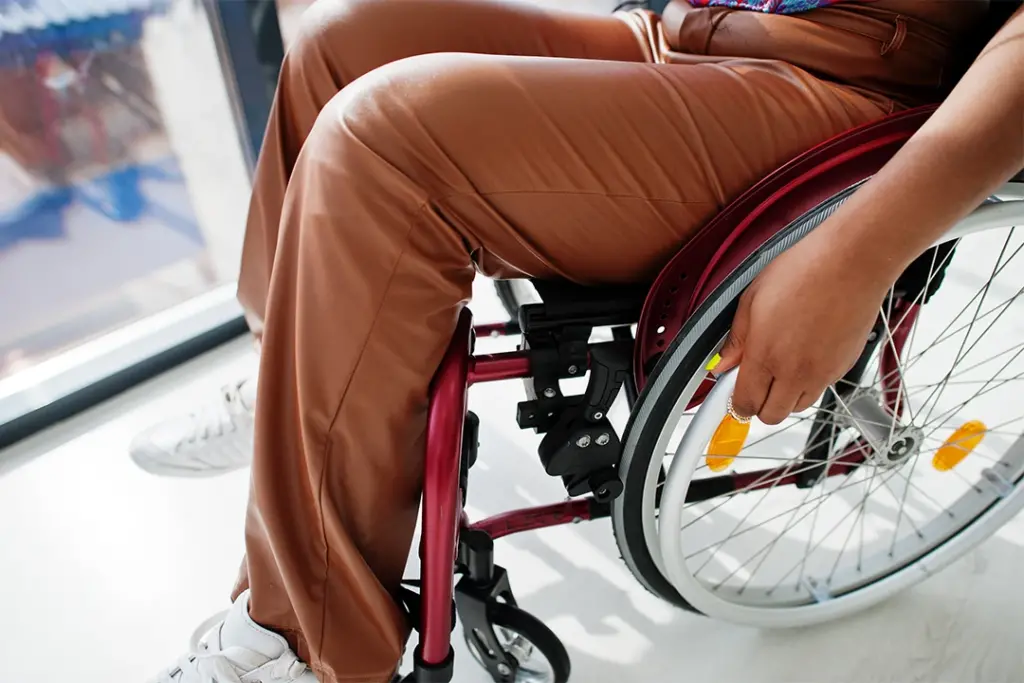 Woman sitting in a wheelchair in front of a window